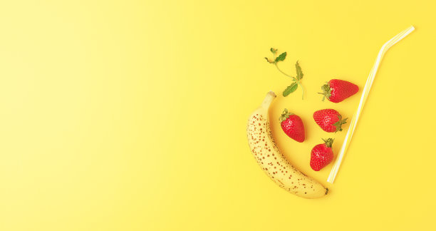 香蕉草莓冰沙装饰薄荷在黄色的背景。五彩缤纷的夏季食物。创意健康饮食理念。平铺，拷贝空间图片下载