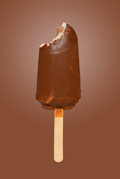 新鲜的巧克力外冰棒，咬一口棕色背景图片下载