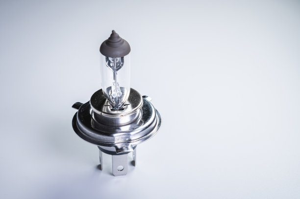 一个新的卤素灯与一个H4煤渣灰色渐变背景。用于汽车外部照明系统的新汽车部件图片下载