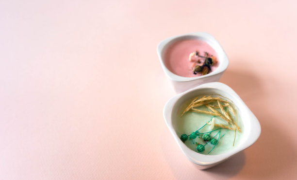 这是一幅极简主义的作品，两根手工蜡烛分别用蓝色和粉色放在蓝色的正方形纸上。物体在浅粉色的背景与纸纹理。手工蜡烛概念由天然成分。礼物。前视图。水平的照片图片下载