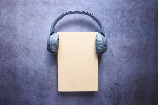 有声书的概念。耳机和书放在木桌上图片下载
