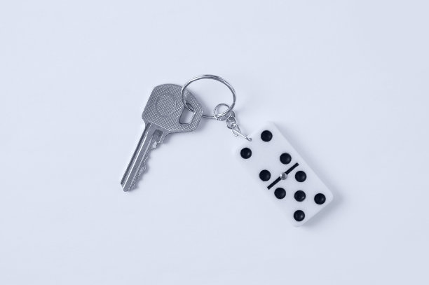 钥匙与钥匙链在模仿多米诺近景上的白色背景。图片下载