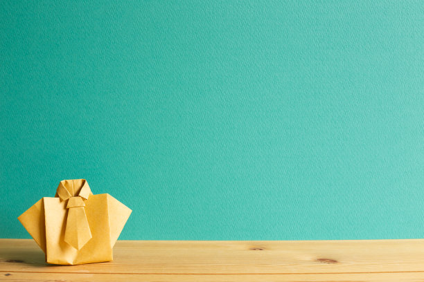 黄色纸衬衫折纸木桌与薄荷绿色背景。本空间图片下载