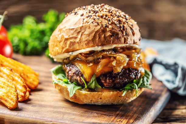 牛肉汉堡配焦糖洋葱，芝麻菜和融化的奶酪图片下载