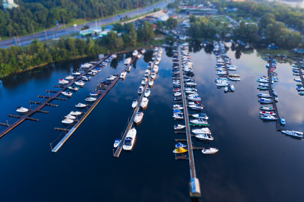 航拍的城市码头与许多船停泊在甚至排在码头在蓝色的水与透视。倾斜的转变。图片下载