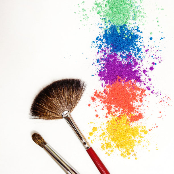 明亮的眼影在不同颜色的彩虹和化妆刷在白色的背景。图片下载