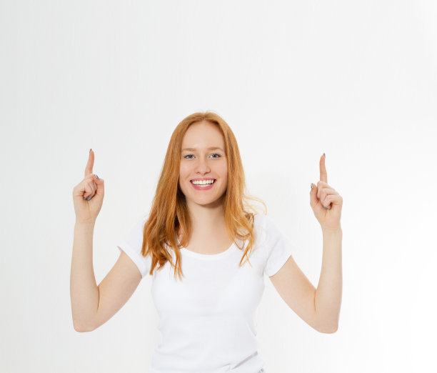 照片微笑的红发女士孤立在白色的背景指向她的手指，有伟大的创新的想法，理解或解决方案，她刚刚得到。副本的空间。图片下载