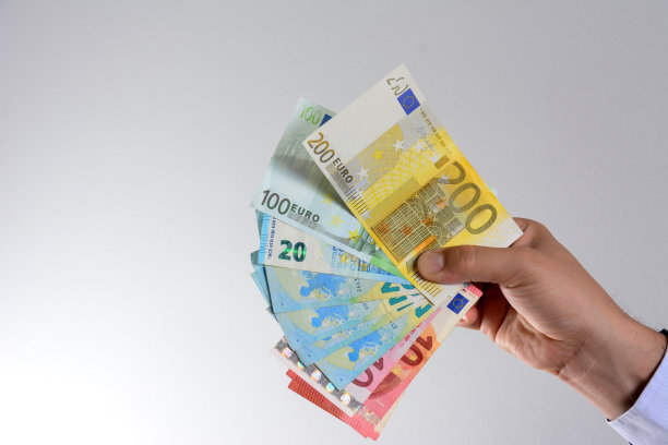 手与欧元货币孤立的灰色背景。图片下载
