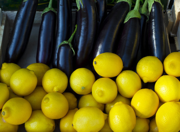 黄色柠檬和紫色茄子的背景。蔬菜和水果。对比图片下载