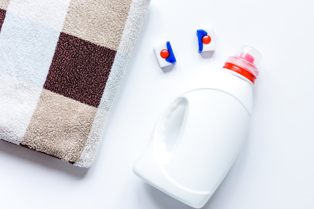 一堆柔和的毛巾与洗涤剂白色背景俯视图图片下载