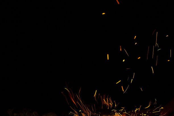 黑色背景上的火花和火焰图片下载
