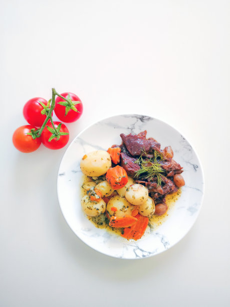 美味的自制法国食谱，名为“法式炖牛肉”，用炖牛肉和土豆在白碗里准备食用图片下载