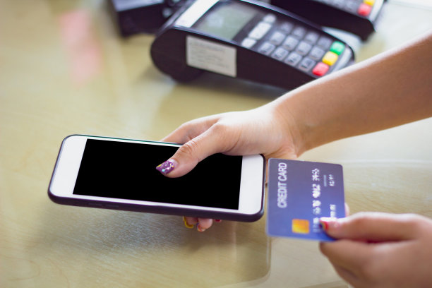 手持智能手机的女性使用信用卡进行手机银行或支付在线购物的剪切路径在手机屏幕上。图片下载