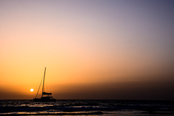 日落时帆船的剪影图片下载