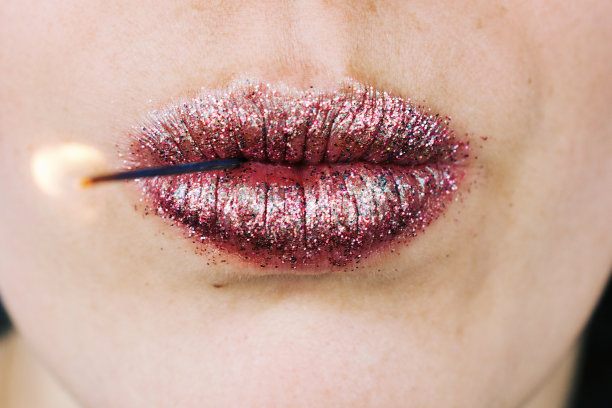 女人的嘴唇拿着燃烧的棍棒靠近图片下载