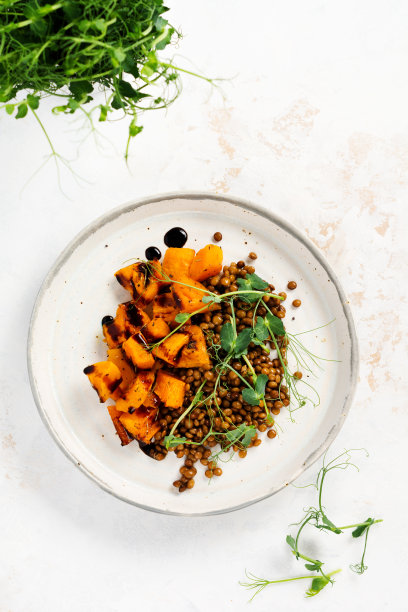 配以烤南瓜、扁豆和香醋酱的沙拉，配以微绿色的豌豆。健康的素食，俯视图。图片下载