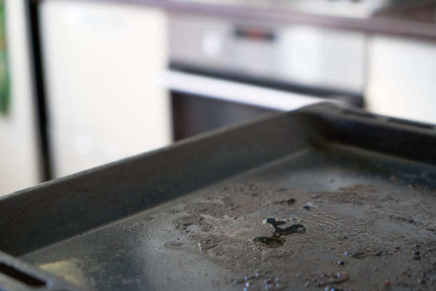 肮脏的烤盘。厨房背景上的脏烤盘图片下载