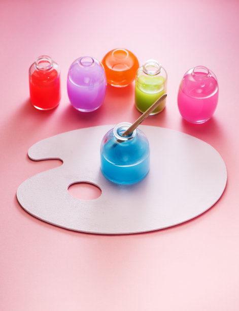 玻璃瓶中的水彩颜料和画家的调色板。图片下载