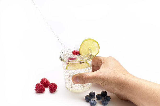 男人在喝柠檬滋补饮料。白色背景，工作室拍摄图片下载