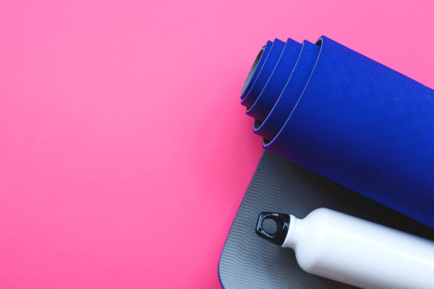 粉红色背景上的亮蓝色瑜伽垫图片下载