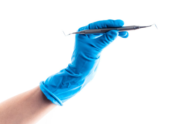 手拿蓝色手套，手持金属牙棒隔离图片下载