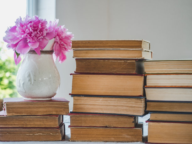 一堆古老的书籍和美丽的鲜花图片下载