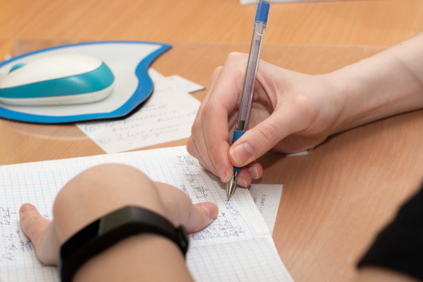 学生用鼠标和键盘在桌上的笔记本上写字。业务,远程学习图片下载