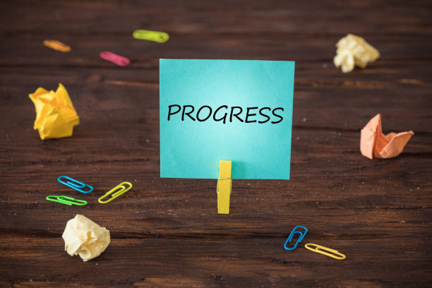 卡片附在带有手写“进步”木质背景的夹子上。发展和实现既定目标的理念图片下载