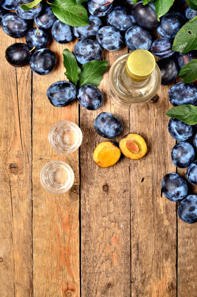 少量的Slivovice，典型的东欧酒精梅子白兰地和酒瓶的背景。从以上观点。垂直的照片。图片下载