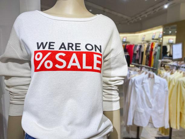 穿着白色毛衣的人体模特，上面写着“我们正在购物中心打折”。季节性促销或黑色星期五概念图片下载