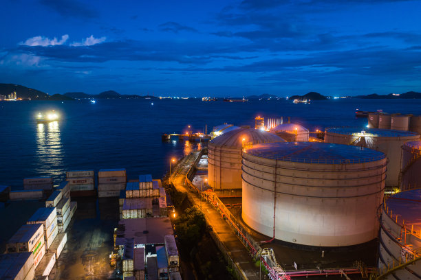 从工业园区俯瞰炼油厂，鸟瞰油气工业，炼油厂储油罐及夜间管线钢图片下载