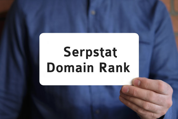 一个穿蓝色衬衫的男人手里的白色标志上写着域名等级图片下载