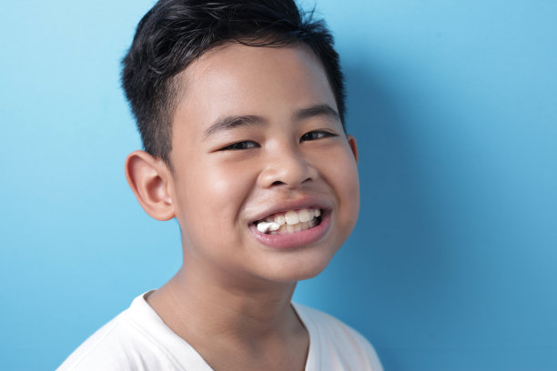 可爱的亚洲男孩吃着泡泡糖和吹气球图片下载