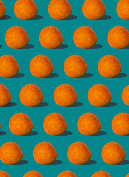 杏黄色的规则图案与坚硬的阴影平铺在柔和的蓝绿色背景上。创意布局夏日水果。图片下载