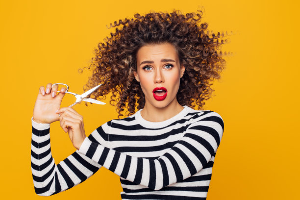 特写照片的一个美丽的女孩拿着头发剪刀，准备改变她的发型图片下载