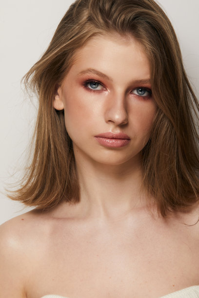 美丽的年轻女子的脸与干净新鲜的皮肤近距离隔离在灰色的背景。美丽的肖像。完美的新皮肤。纯美的模型。青春护肤理念图片下载