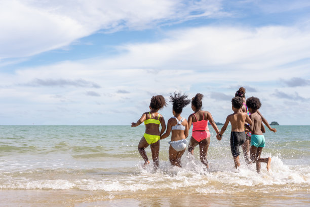 非裔美国人，一群孩子或兄弟姐妹，在假期或夏天，在学校或家庭里，带着手在海里玩耍图片下载