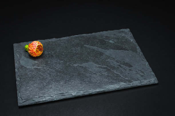 在烹饪照片中使用的黑色背景上的空白石板板。图片下载