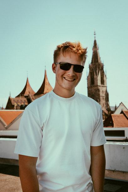 在屋顶上戴着太阳镜的快乐微笑的年轻人图片下载