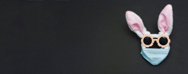 复活节兔子在防护医用口罩隔离概念复活节假期因疫情。复活节病有阳性保存。空间,复制文本。兔耳朵，太阳镜，面具形成的脸图片下载