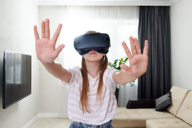 少女戴着虚拟现实眼镜头戴游戏，玩虚拟现实盒。技术，新一代，进步理念。在虚拟现实中试图触摸物体的女孩图片下载