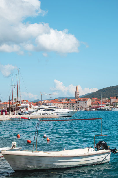 垂直滨水视图的Starigrad，赫瓦尔。旧船在前面的码头，房子和著名的教堂钟楼在远处图片下载
