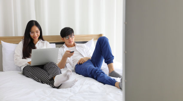 在隔离期间，夫妇戴着口罩在家看电视新闻图片下载