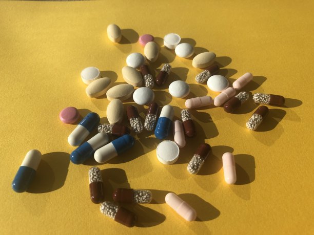黄色背景上有很多五颜六色的药丸。图片下载