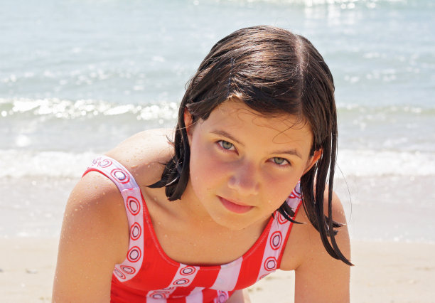 沙滩上的一个白人女孩，看着镜头。图片下载