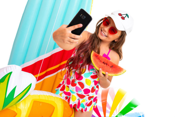 酷酷的女孩，留着十字架般的长发，戴着墨镜，穿着泳衣，站在充气床垫旁边，和一个西瓜自拍图片下载