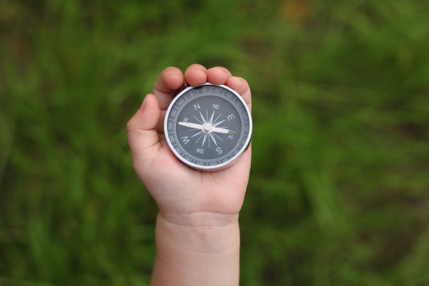 经典导航罗盘在儿童手中自然的背景图片下载