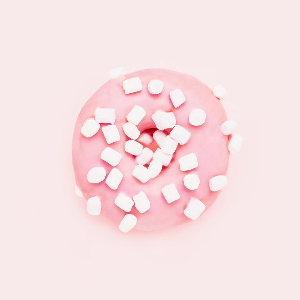 粉红色的甜甜圈，粉红色的背景上有白色的点缀。俯视图，复制空间图片下载