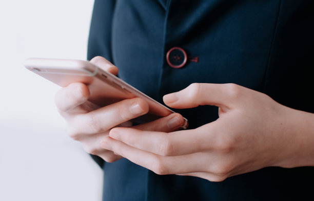 手握空白屏幕的智能手机。女性的手和短信手机。办公室。图片下载