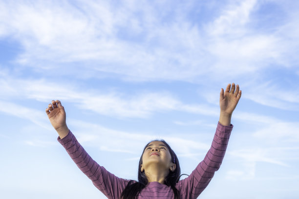 小女孩张开双臂望着天空图片下载